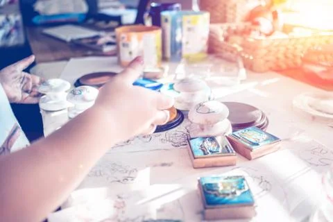 Boy is having fun while playing with stamps and tempera paints on wooden work Stock Photos