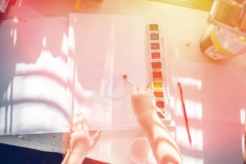 Boy is having fun while playing with stamps and tempera paints on wooden work Stock Photos