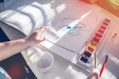 Boy is having fun while playing with stamps and tempera paints on wooden work Stock Photos