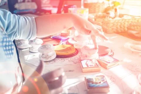 Boy is having fun while playing with stamps and tempera paints on wooden work Stock Photos