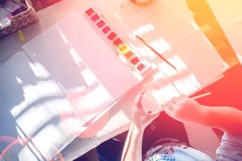 Boy is having fun while playing with stamps and tempera paints on wooden work Stock Photos