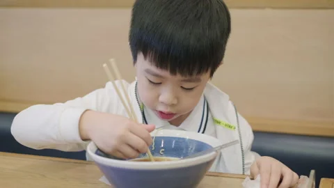 Boy having noodle in the restaurant Stock Footage 142801860