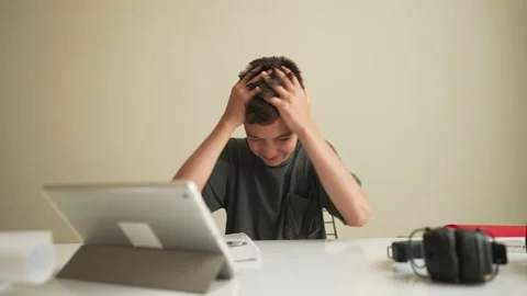 Boy having problem with homework. Child using tablet for home learning, School Stock Footage 195785684