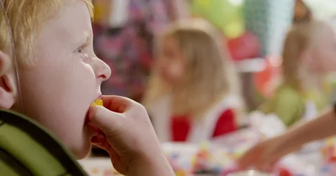 Boy having a slice of lemon during a birthday party in classroom Stock Footage 58573729