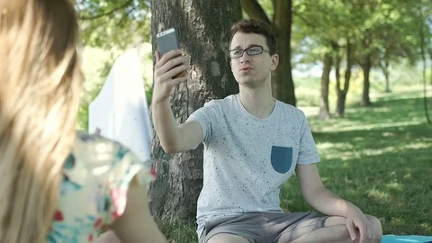 Boy having a videocall on smartphone while his friend is studying, steadycam sho Stock Footage 78625523