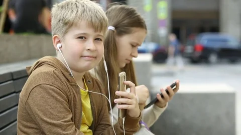 Boy with headphones. Children using app on smart phone.  Stock Footage 77845594