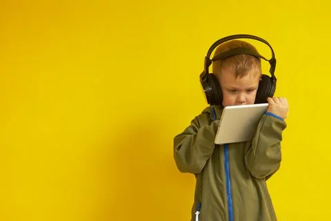 A boy with headphones is studying a tablet computer Stock Photos