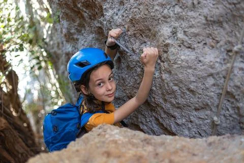 Boy in a helmet and with a backpack in the mountains. the child is on vacatio Stock Photos