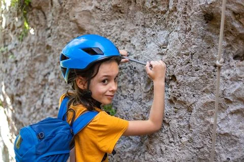 Boy in a helmet and with a backpack in the mountains. the child is on vacatio Stock Photos