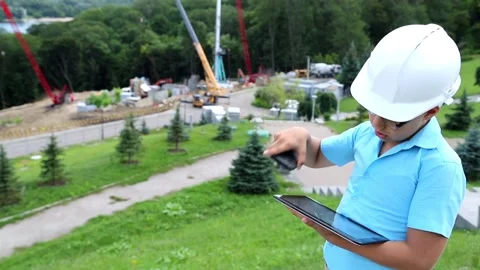 The boy in the helmet and with the tablet communicates by phone Stock Footage 97266774