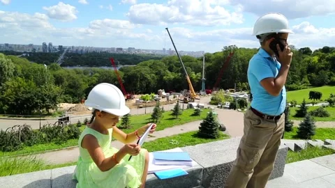 A boy in a helmet reports by phone on the progress of construction. Stock Footage 97266070