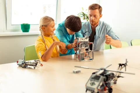 Boy helping his classmate building her robot. Fotos de archivo