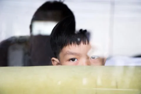 Boy hide himself behind sofa in the mirror room Stock Photos