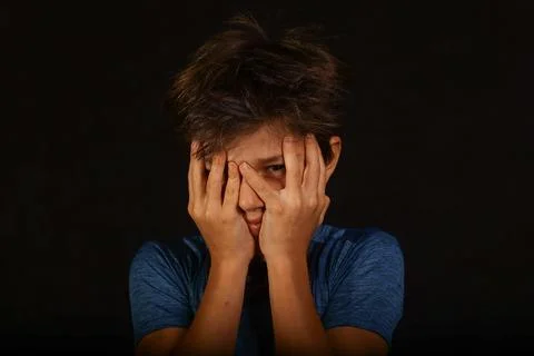 Boy hiding face with hands expressing fear anxiety and stress, fear, anxiety 스톡 사진