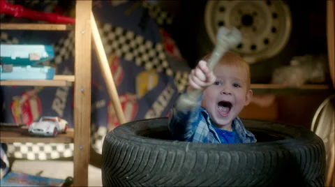 Boy Hiding in Pile of Tyres Stock Footage 62221094