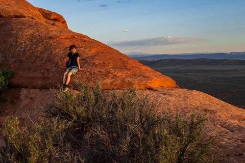 Boy Hiking at Sunset on Devils Garden Trail, Utah Stock Photos