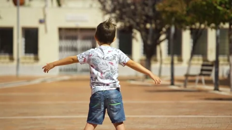 Boy on his back skating with the arms open on a hoverboard in a town square. Stock Footage 137522810