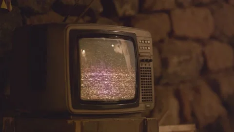 Boy is hitting the glitching tv. Old broken television Stock Footage 194936955