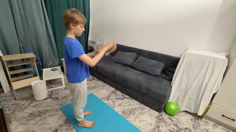 Boy hitting ping pong paddle with hand in living room, playful child activity, Stock Footage 335645928