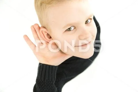 The boy hold his hand near ear. View from above Stock Photos