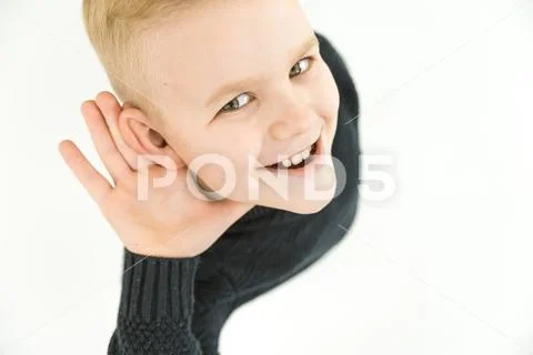 The boy hold his hand near ear. View from above Stock Photos