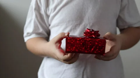 The boy hold a red gift, Valentines day. Christmas gift. Stock Footage 147452751