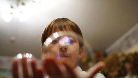 Boy hold the soap bubbles on his hand in a cafe 스톡 사진