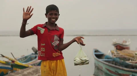 Boy holding a bag with fish and waving in Sri Lanka Stock Footage 49365996