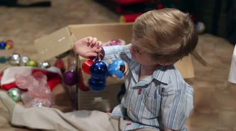 The boy is holding balls for the Christmas tree Stock Footage 58449283
