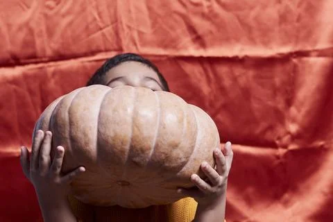 A boy holding a big pumpkin Stock Photos
