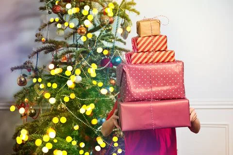 Boy holding big stack of New Year presents covered Stock Photos