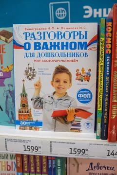 Boy Holding a Book in a Store While Exploring Educational Resources for Children Stock Photos