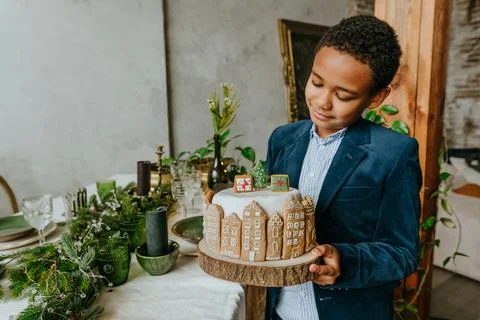 Boy holding Christmas gingerbread cake at home Stock Photos