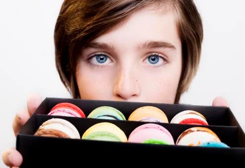 Boy holding dessert macarons in black wooden box 写真素材