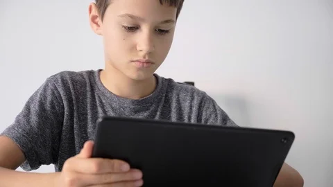 Boy holding digital tablet computer, watching video, online learning, play games Stock Footage 127464069