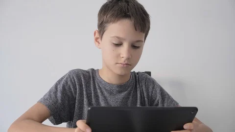 Boy holding digital tablet computer, watching video, online learning, play games Stock Footage 127683062
