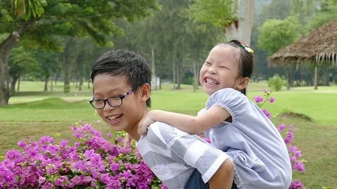 Young girl carrying sister giving piggyback ride Stock Photo