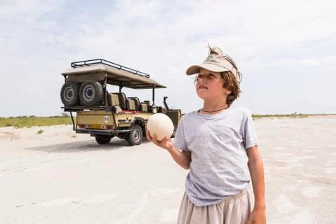Boy holding up a large ostrich egg Stock Photos