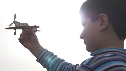 The boy is holding a model of an airplane in the sun Stock Footage 88439543