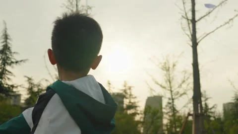 Boy Holding Paper Airplane Looking at City Skyline at Sunset Vídeos de archivo 339074264
