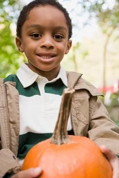 Boy holding a pumpkin Stock Photos