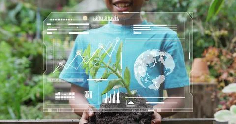 Boy holding seedling while camera pulling back, HUD overlaying charts and globe, Stock Photos
