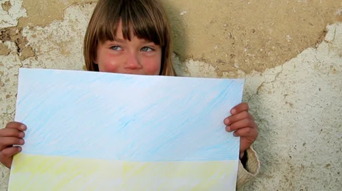 Boy holding a sheet of paper the background of an old wall. Stock Footage 38012075