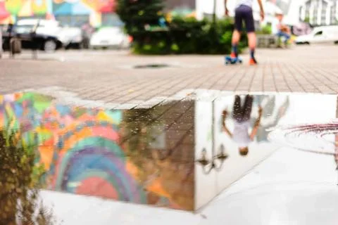 A boy holding a skiing board reflected in a pool of water. Stock Photos