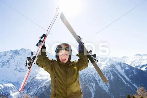 Boy Holding Skis Above His Head
