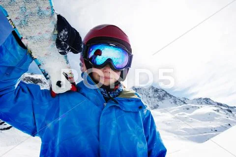 Boy Holding Skis On Snowy Mountain