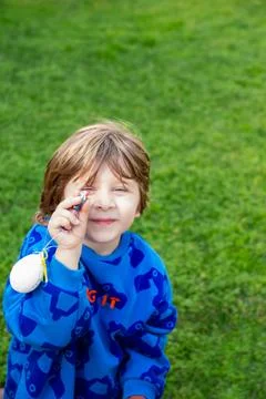 Boy holding small chocolate egg looking at camera Stock Photos