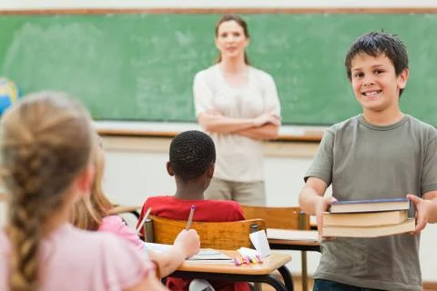 Boy holding stack of books 스톡 사진