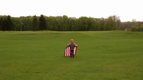 A boy holding a US flag in the hands of Stock Footage 63382121