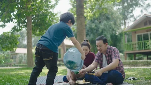 Boy holds a basin with compost poured on the floor to learn. Stock Footage 151502346